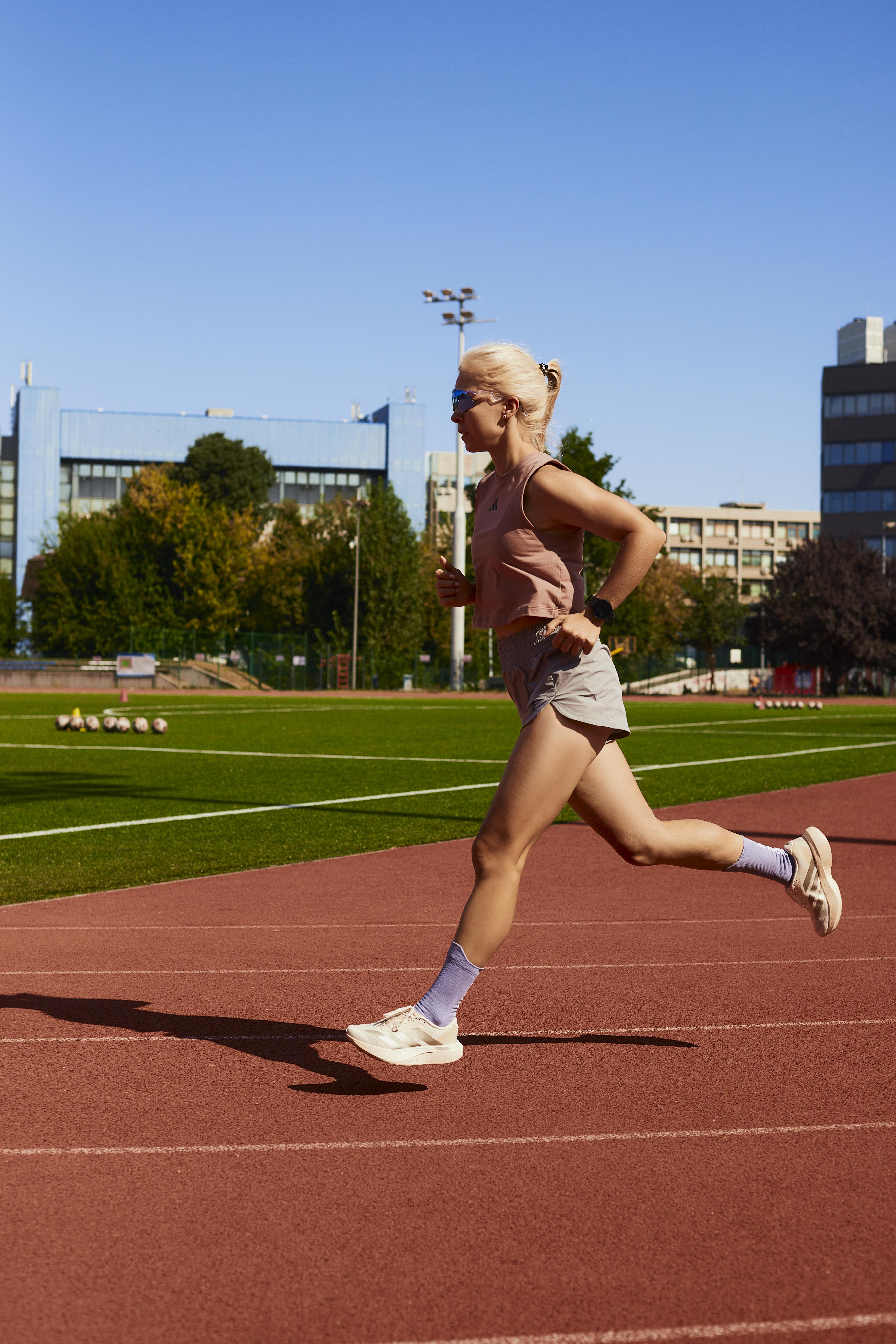 Running coach working with an athlete on the track